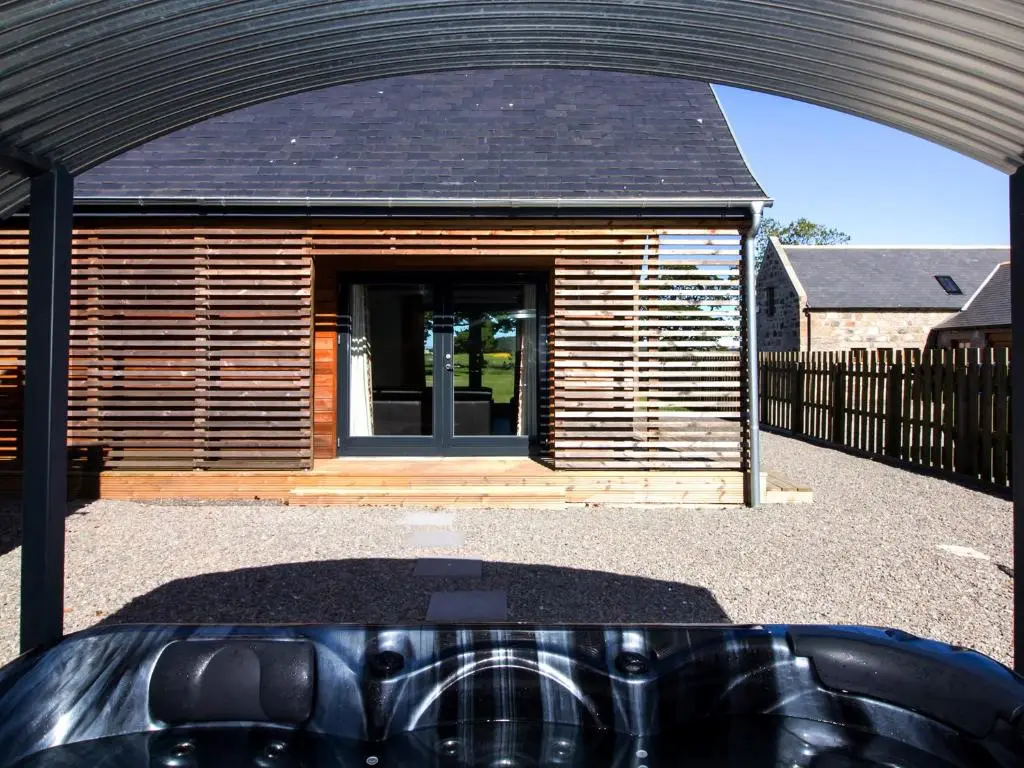 a wooden house with a car parked in front of it at Nef-Stedi in Kirktown of Bourtie