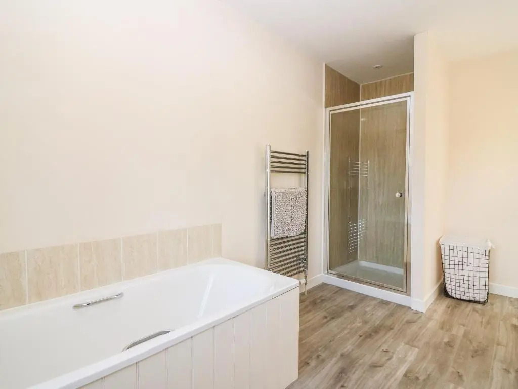 a bathroom with a large tub and a shower at White Hillocks Cottage in Inchmill