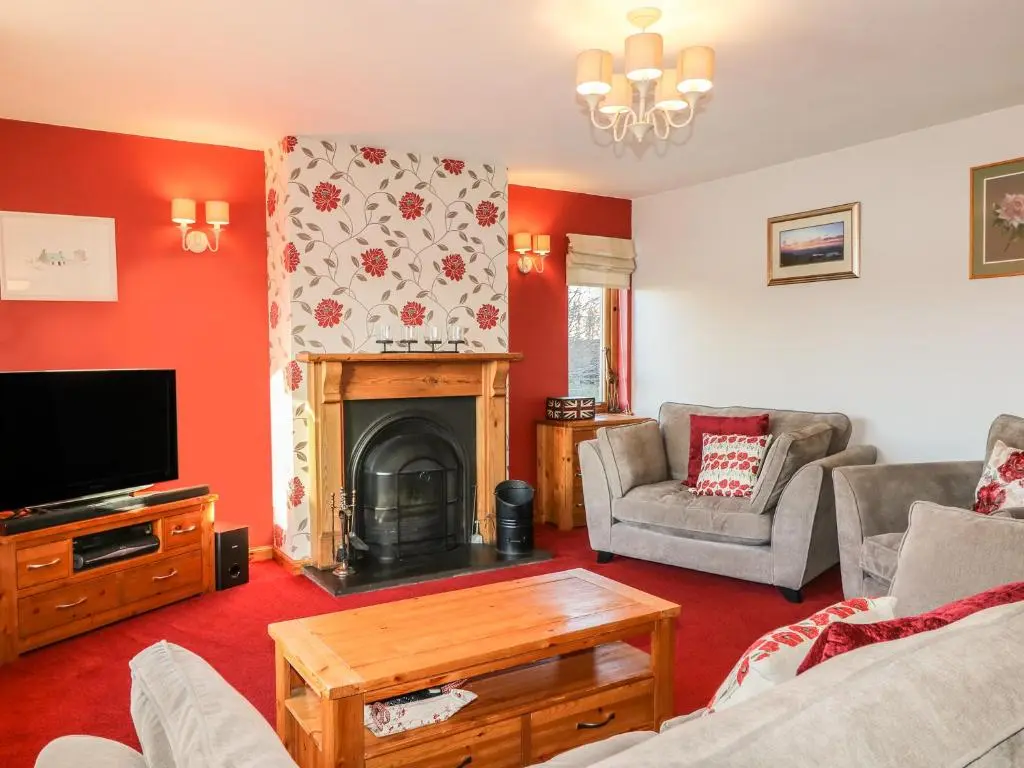a living room with a fireplace and a tv at Corriemhor Beag in Cromdale
