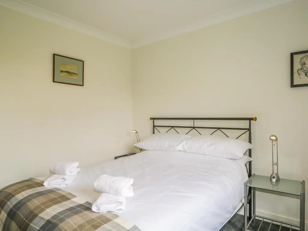 a white bed with white sheets and pillows at Glaven in Bonar Bridge