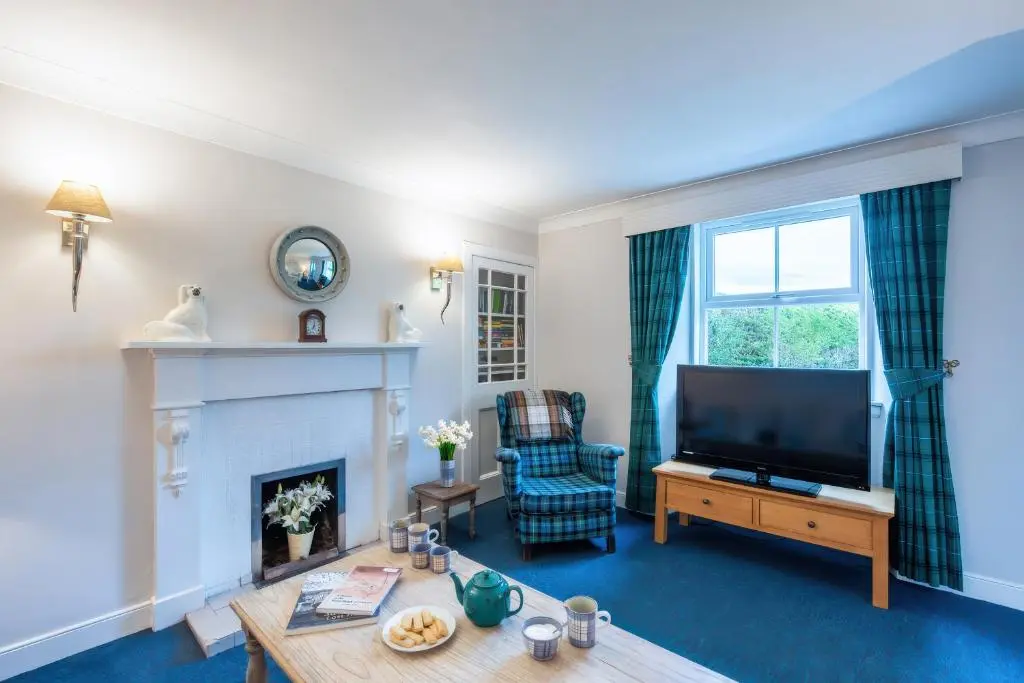 a living room with a tv and a fireplace at Kerrisdale in Dornoch