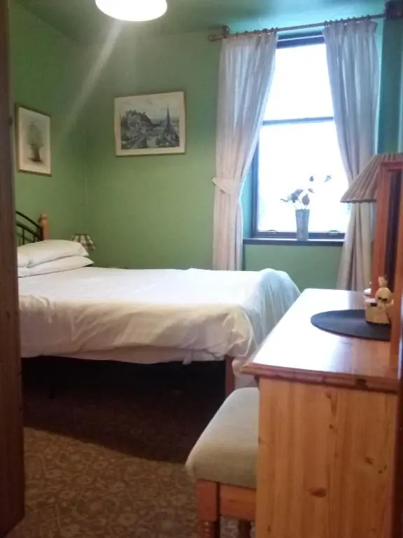 a bedroom with two beds and a window at Meadowside Cottages in Balavil