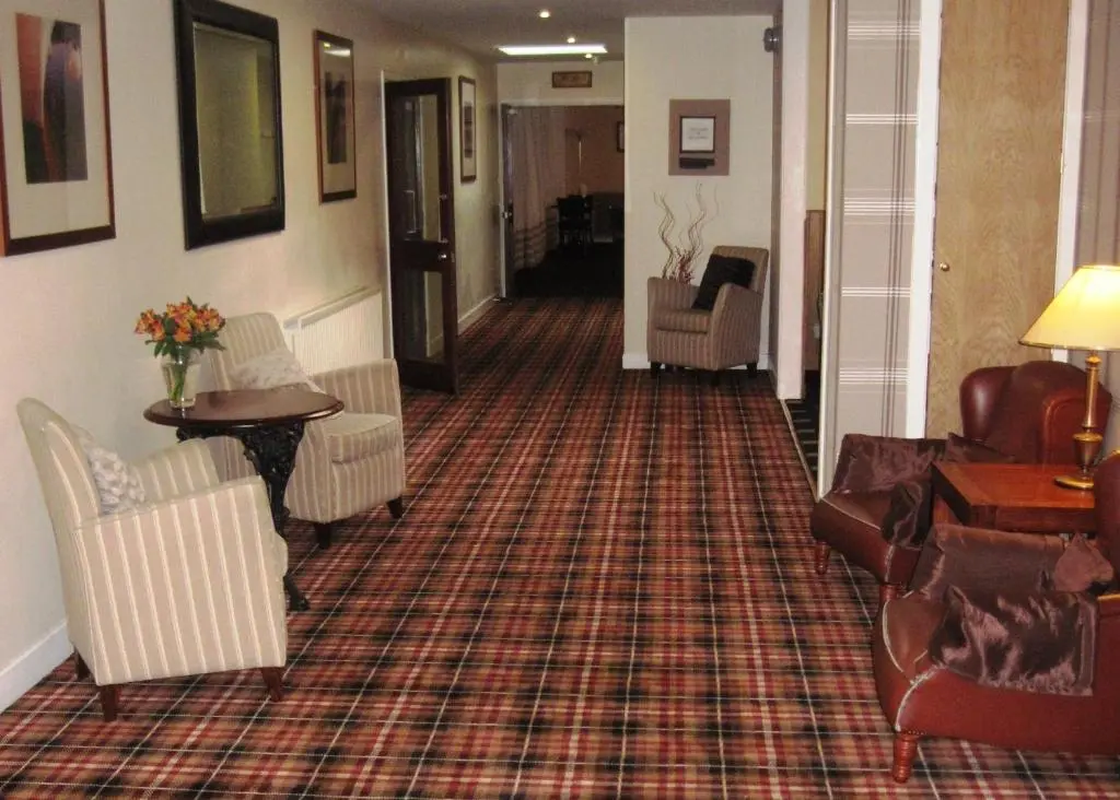 a living room with couches and chairs on a carpet at Norseman Hotel in Wick