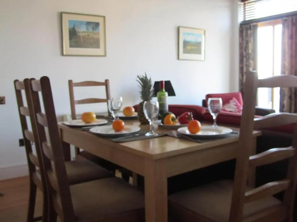 a dining room table with oranges and wine glasses on it at Bridge Street Apartments in Inverness