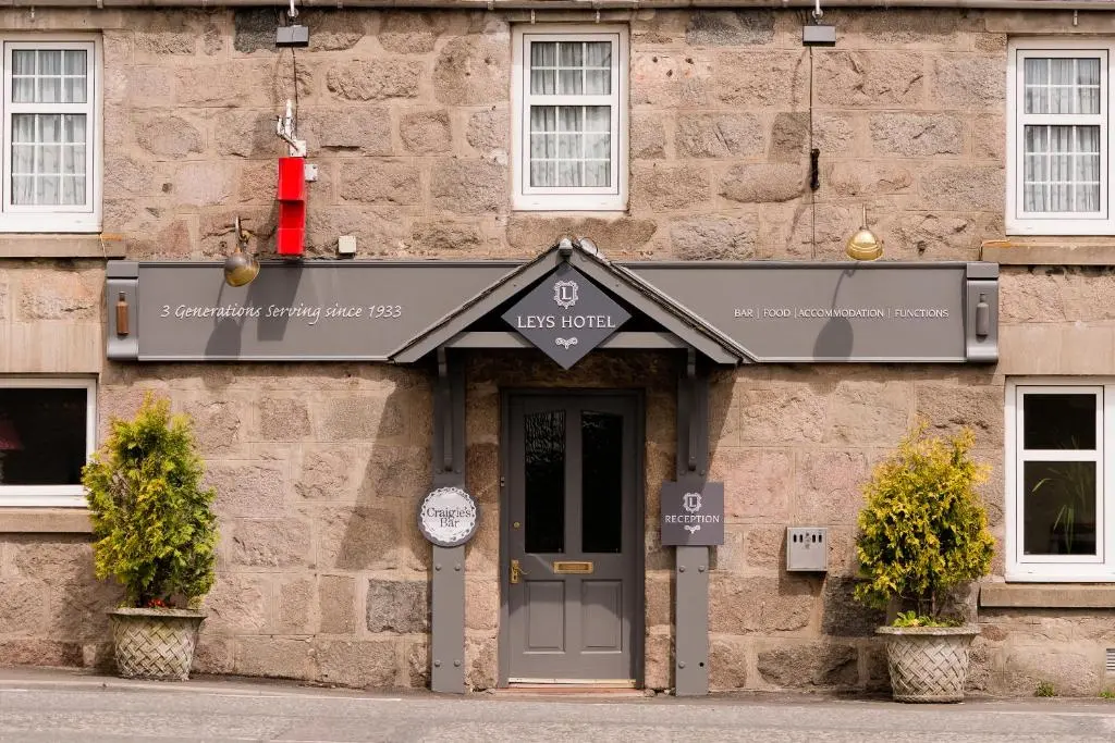 a stone building with a sign above a door at Leys Hotel in Aberdeen
