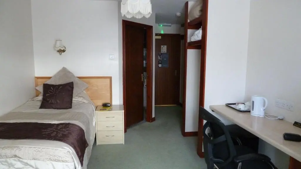 a hotel room with a bed and a desk and a room at Leys Hotel in Aberdeen