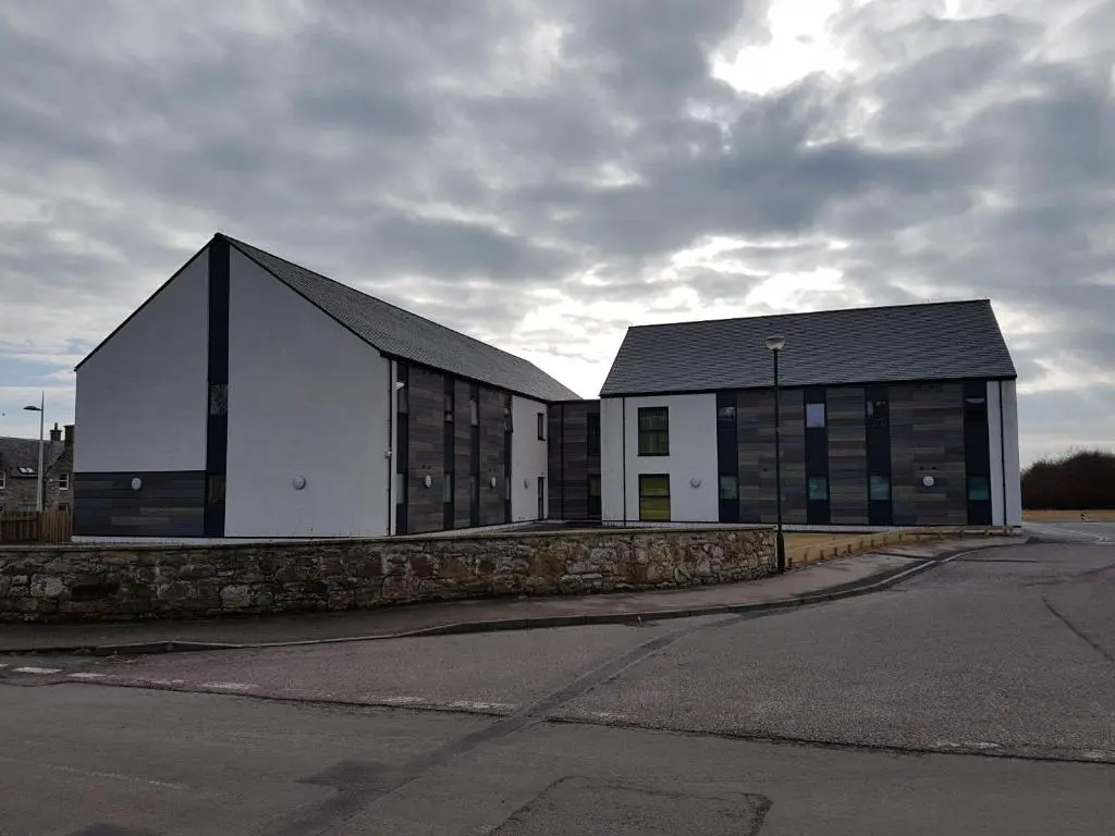 a large white building with a black roof at UHI Dornoch- Campus Accommodation in Dornoch