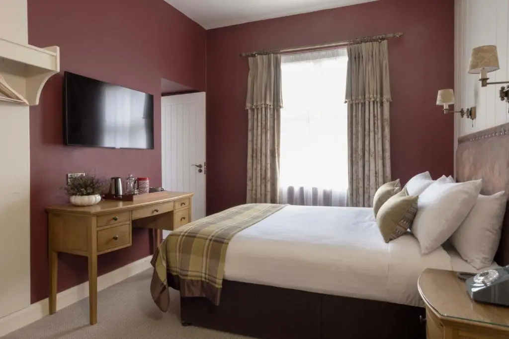 a hotel room with a bed and a window at Balmoral Arms in Ballater