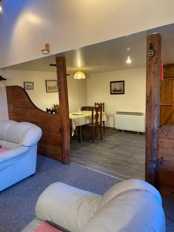 a living room with a couch and a table at Parkmore Holiday Cottages in Dufftown