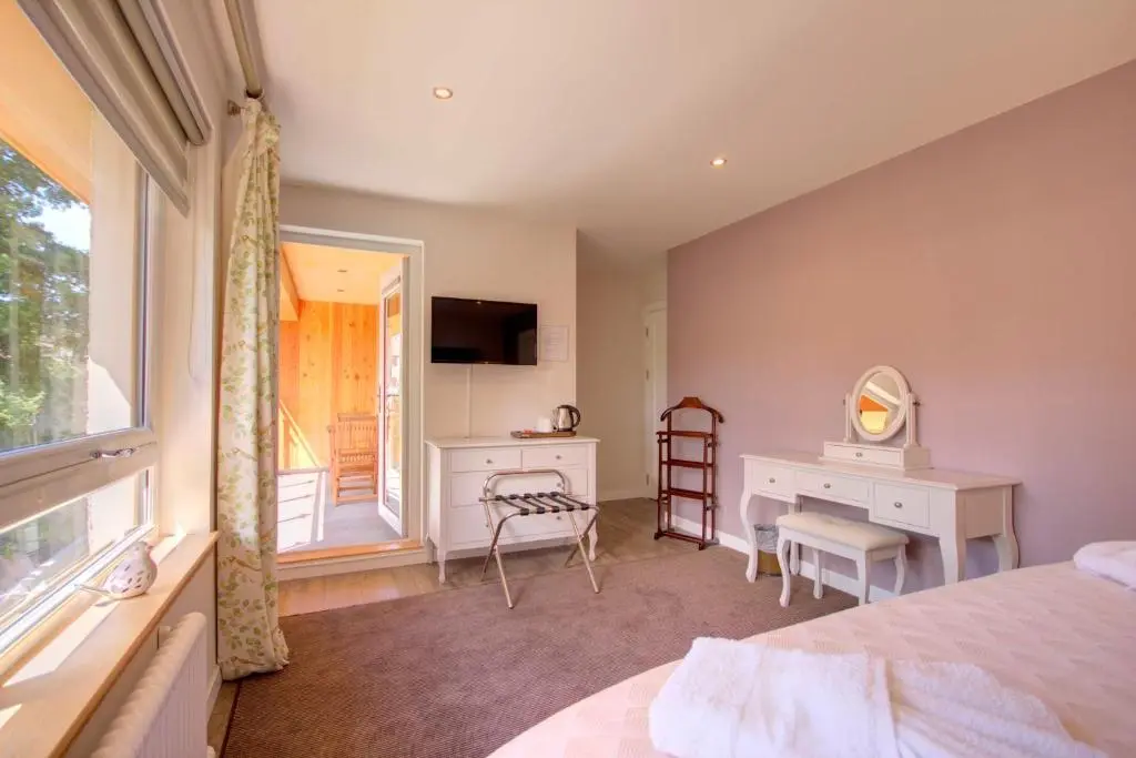 a bedroom with a bed and a desk and a window at Loch Earn in Inverness