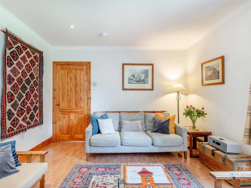 a living room with a couch and a table at The Old Laundry in Grantown on Spey