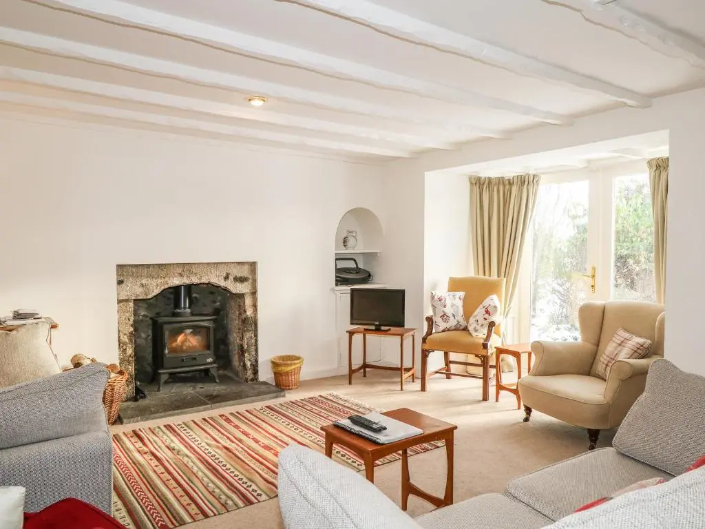 a living room with a fireplace and a couch and chairs at Newlands in Archiestown
