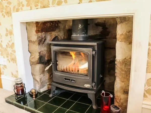 a fireplace with a stove in a room at Seascape in Buckie