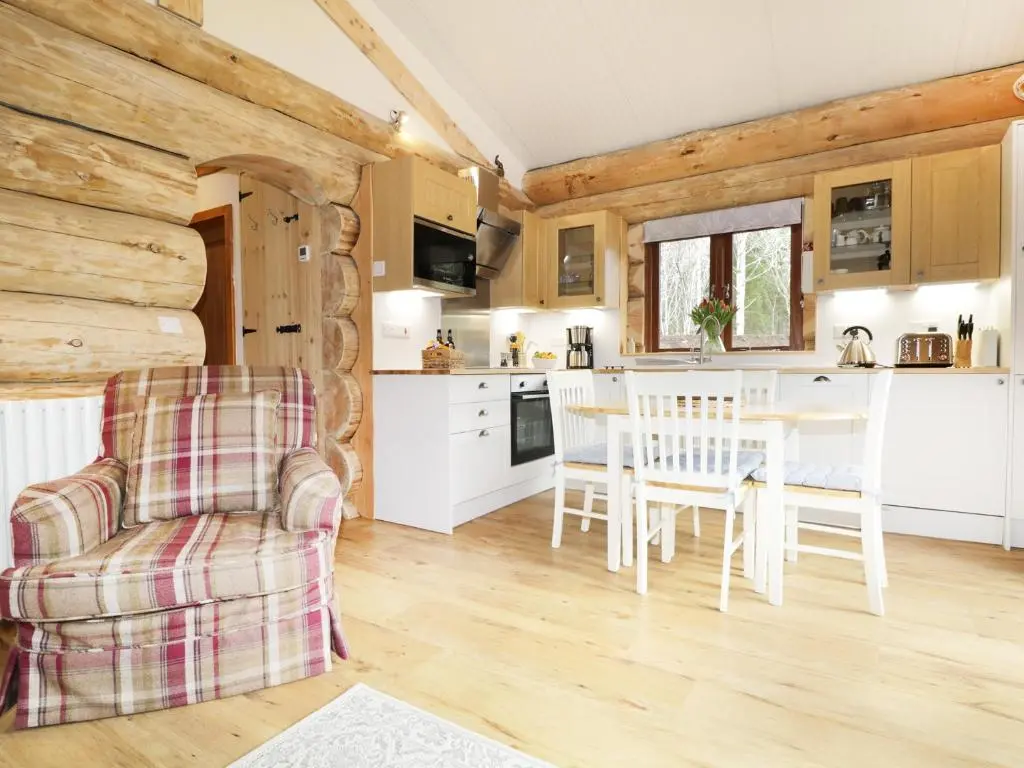 a kitchen and dining room with a table and chairs at Heron Lodge in Inverness