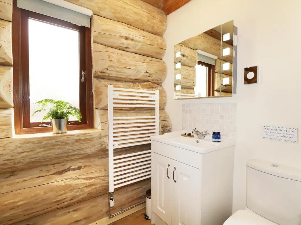 a bathroom with a wooden wall at Heron Lodge in Inverness