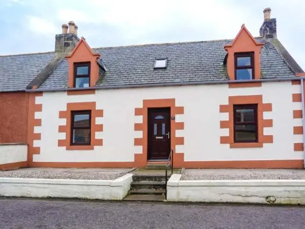 a large white house with a black roof at Grace Cottage in Buckie