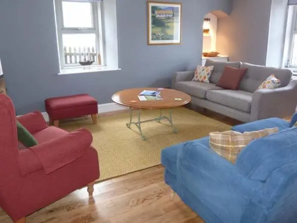 a living room with a couch and a table at Grace Cottage in Buckie