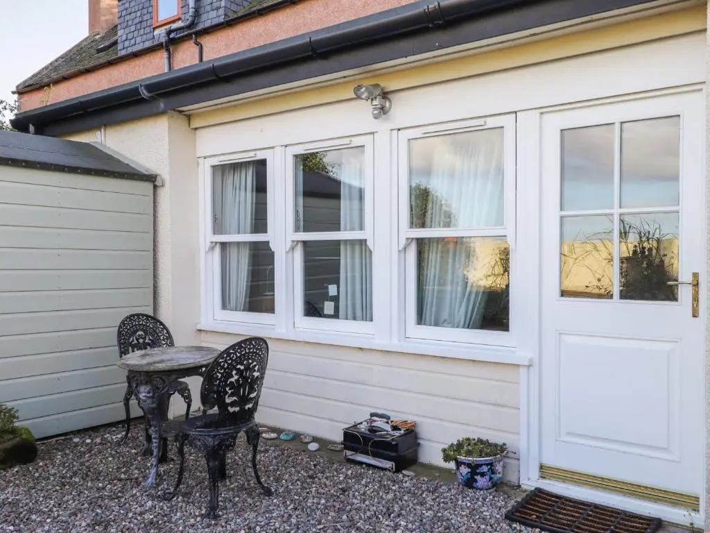 a table and two chairs in front of a house at Seaview in Nairn