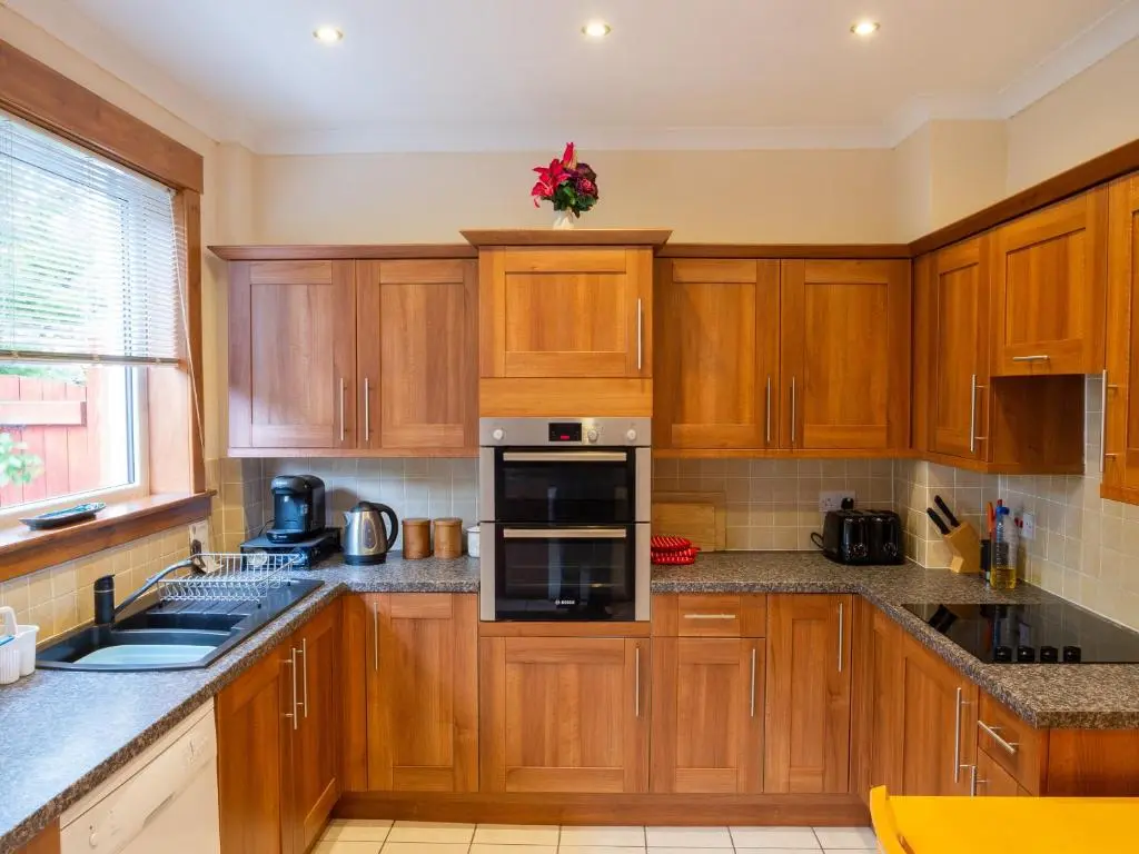 a kitchen with wooden cabinets and a stove top oven at BalMara in Hopeman