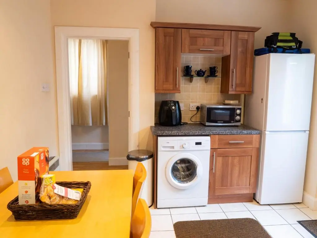 a kitchen with a white refrigerator and a washing machine at BalMara in Hopeman