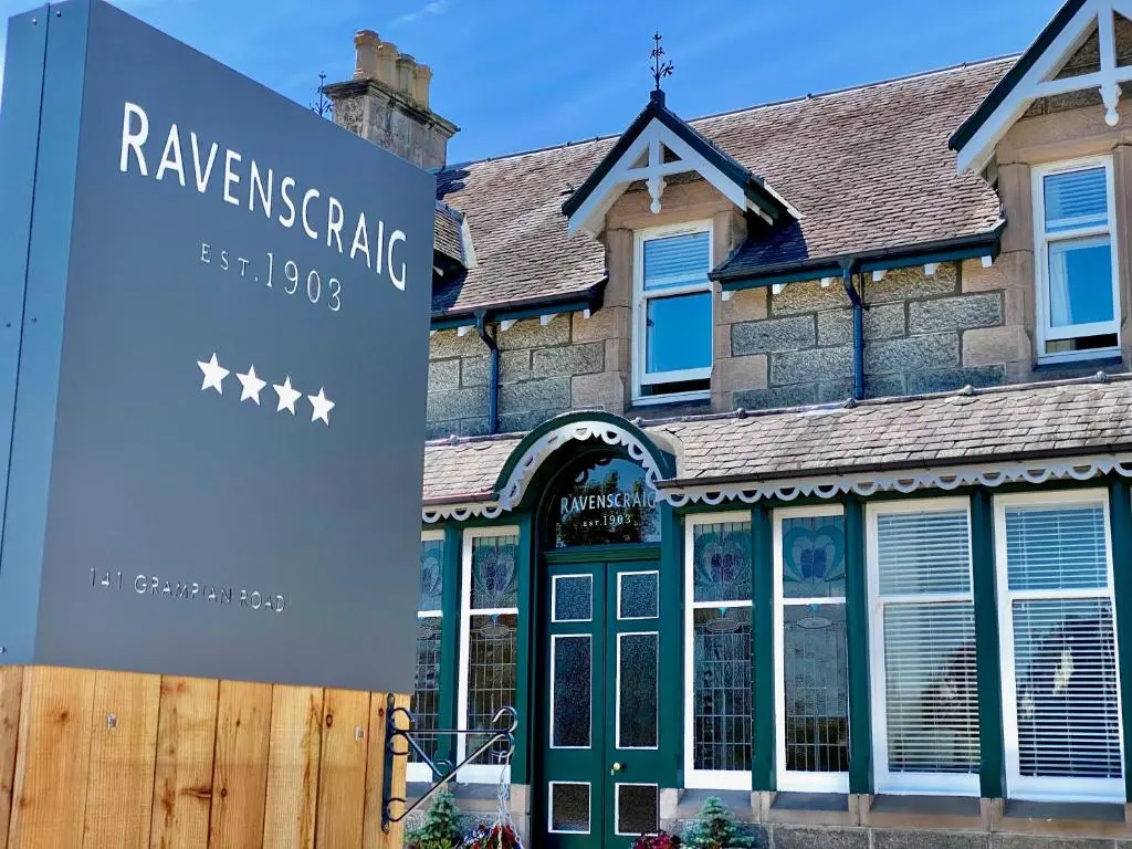 a house with a sign in front of it at Ravenscraig Guest House in Aviemore