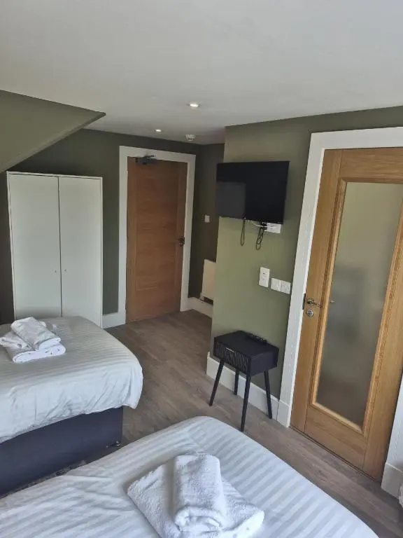 a hotel room with two beds and a television at Haughton Arms Hotel in Alford