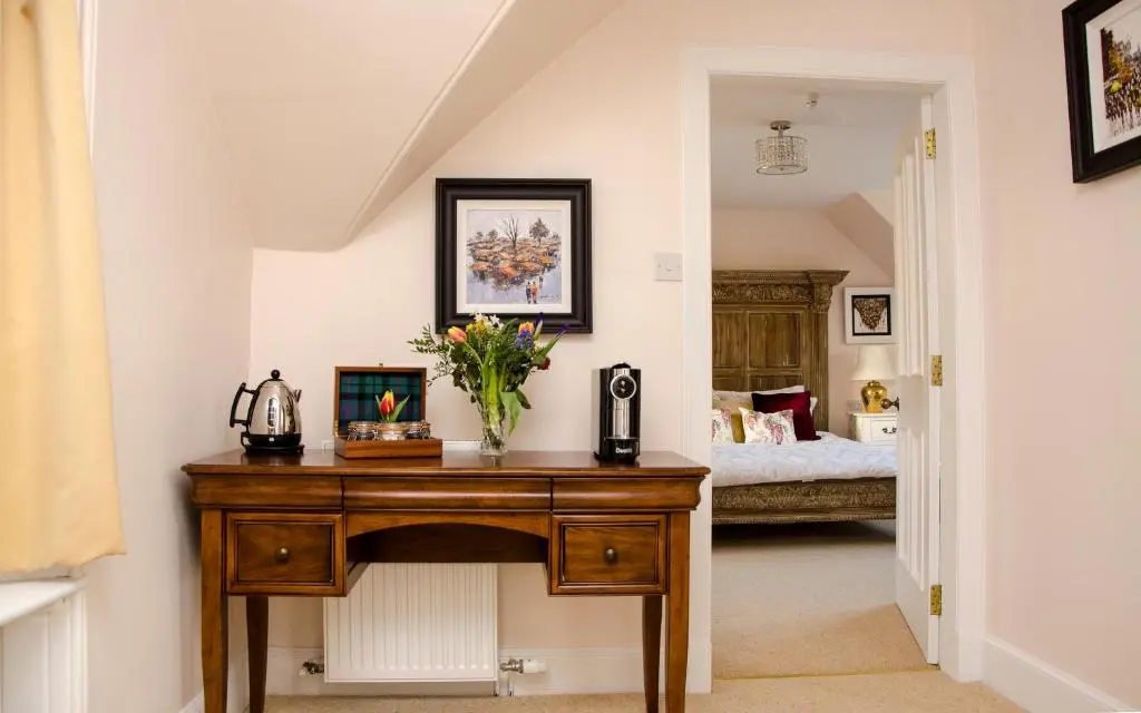 a room with a table with a vase of flowers on it at Mount Barker in Grantown on Spey