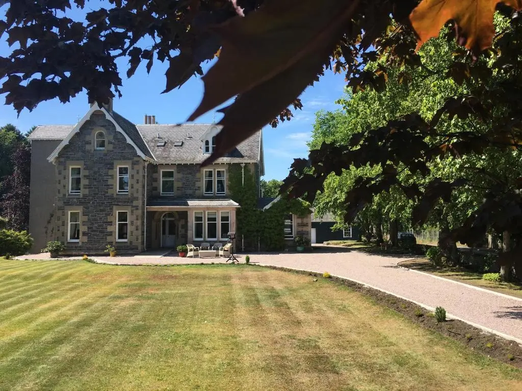 a large stone house with a large yard at Mount Barker in Grantown on Spey
