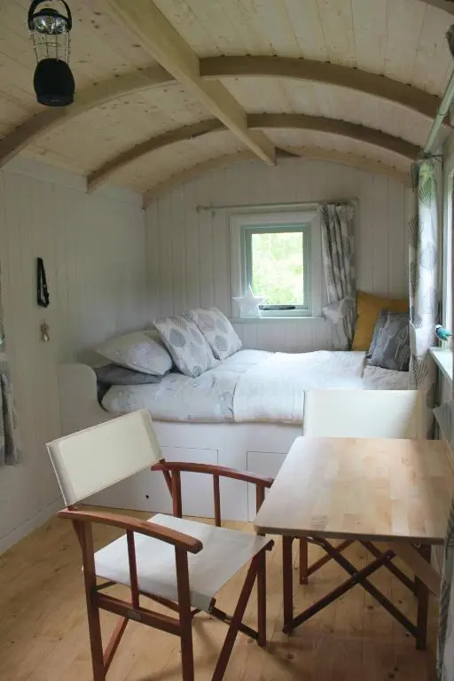 a bedroom with a bed and a table and chairs at Howe of Torbeg in Ballater