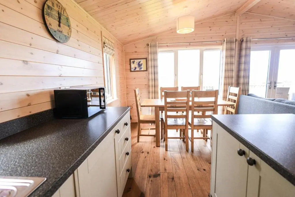 a kitchen and dining area of a log cabin at Burgie Woodland Lodges in Forres