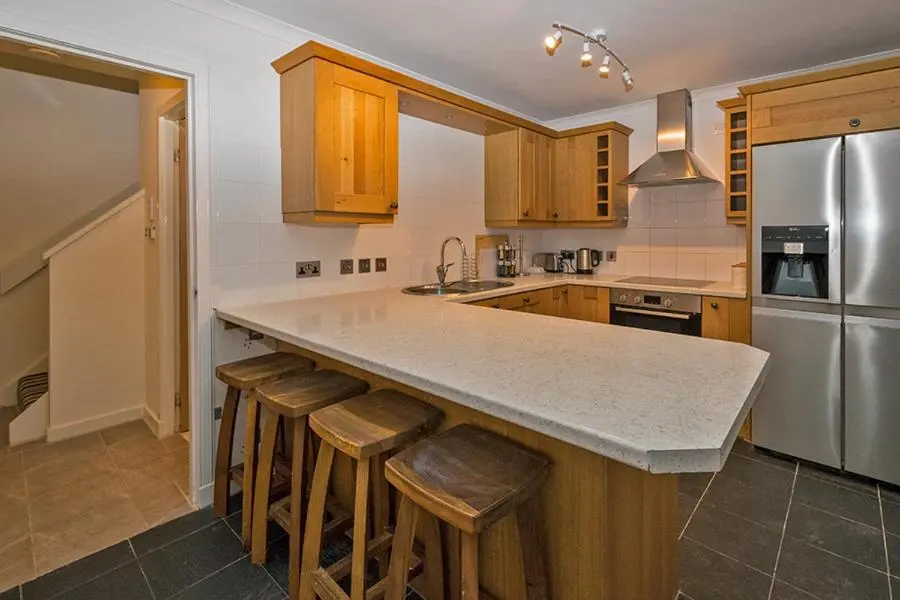 a kitchen with a large island with bar stools at 37A Commerce Street in Lossiemouth