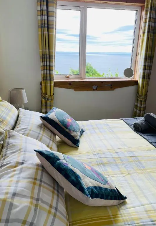 a bedroom with two beds with pillows and a window at The Stroops in Helmsdale