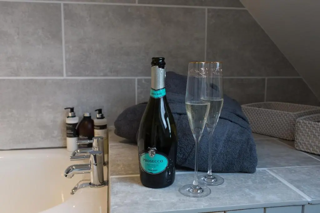 a bottle of wine and a glass on a counter at Cairn Leuchan in Ballater