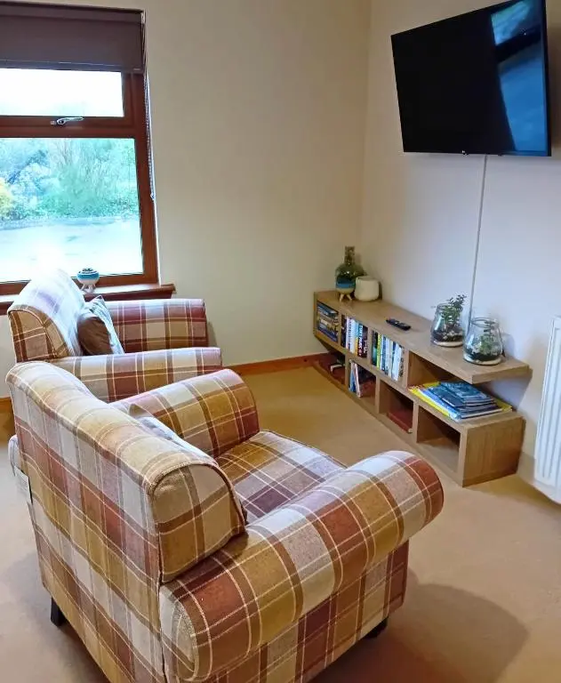 a living room with two couches and a flat screen tv at Deveron Lodge B&B in Turriff
