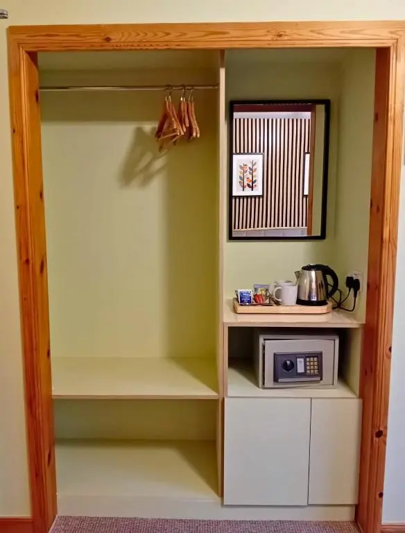 a cupboard with a microwave and a microwave at Deveron Lodge B&B in Turriff