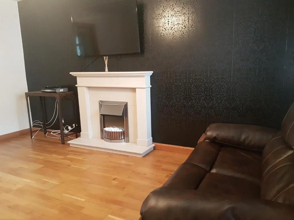a living room with a couch and a fireplace at Jane's Place Free Parking in Inverness