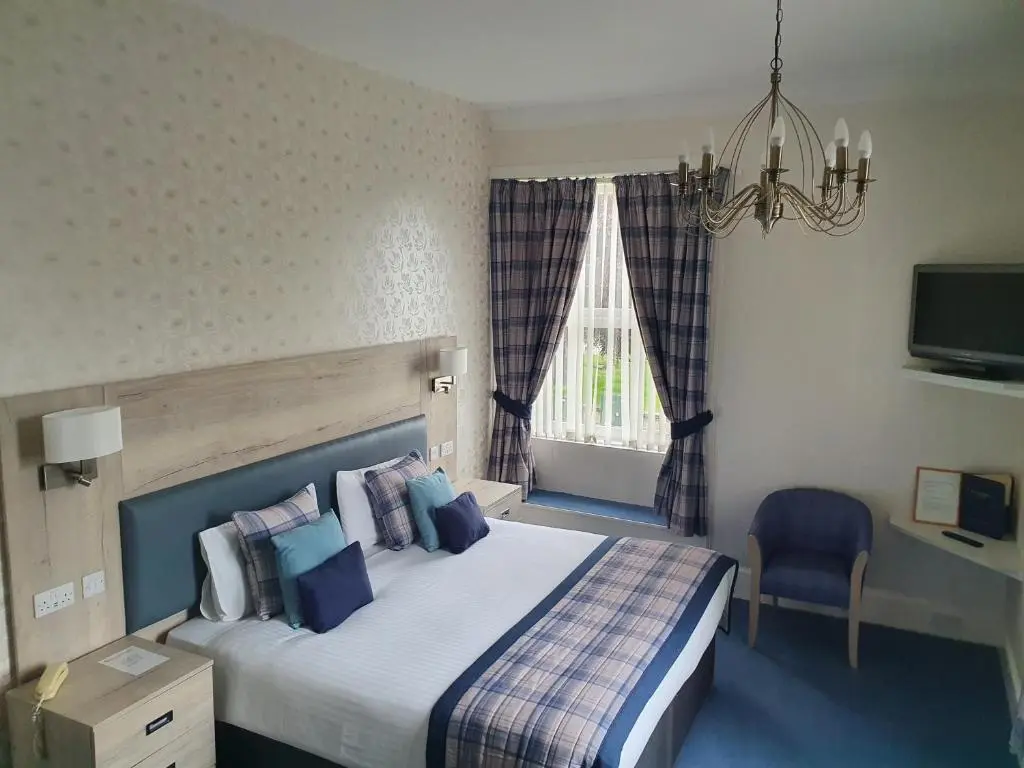 a bedroom with a bed and a chandelier at Sunninghill Hotel in Elgin