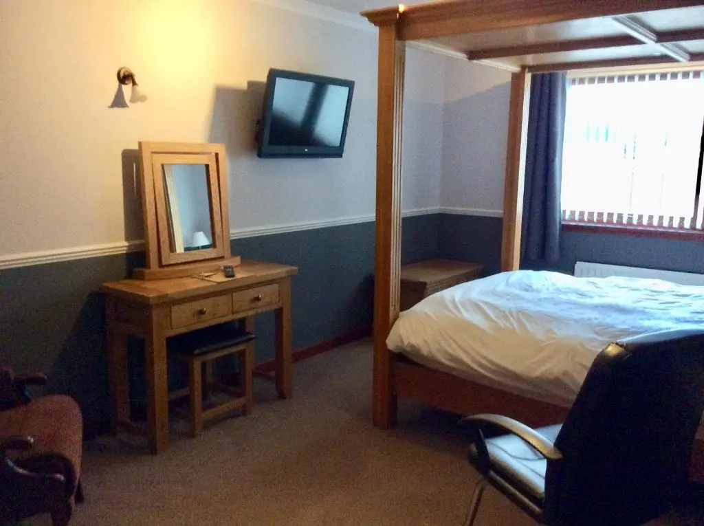 a bedroom with a bed and a mirror and a bed sidx sidx sidx at Hillview Park in Beauly