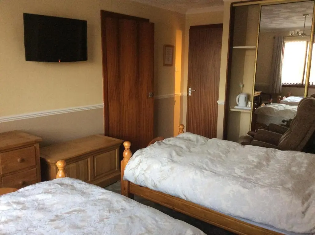 a hotel room with two beds and a mirror at Hillview Park in Beauly