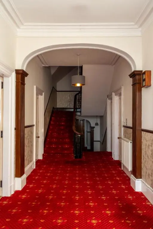 an empty hallway with a red carpet at Station Hotel in Ellon