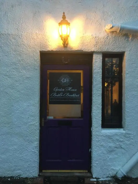 a building with a blue door and a light above it at Gordon House in Tomintoul