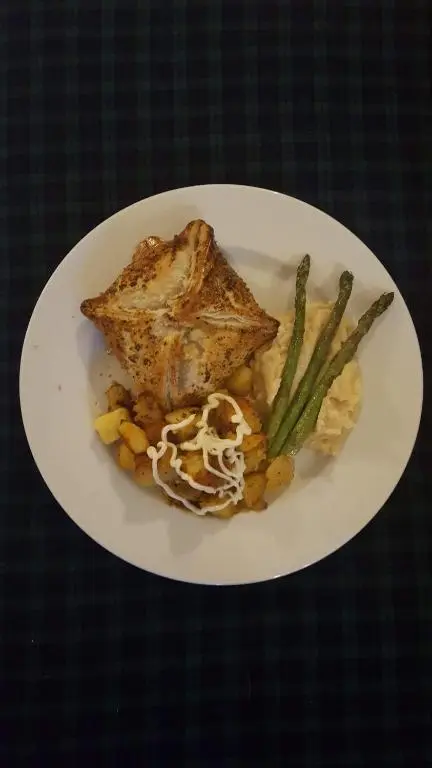a plate of food with fish and vegetables on a table at Gordon House in Tomintoul