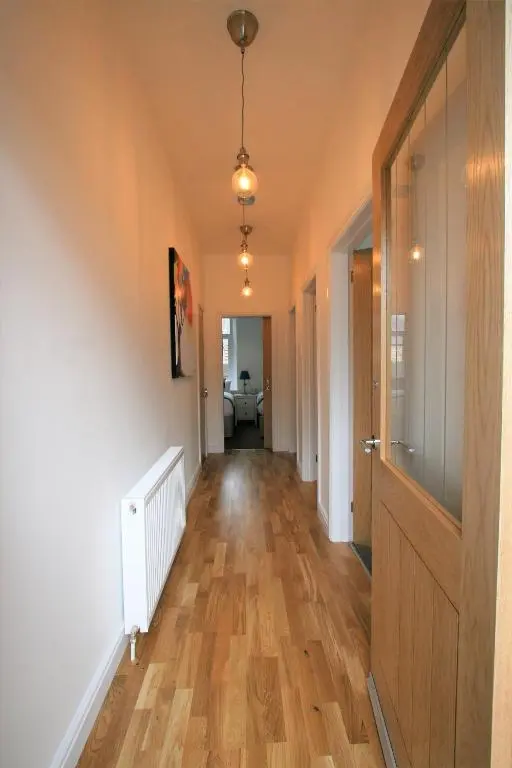 an empty hallway with a wooden floor and a door at Dryburgh Apartment No3 in Inverness