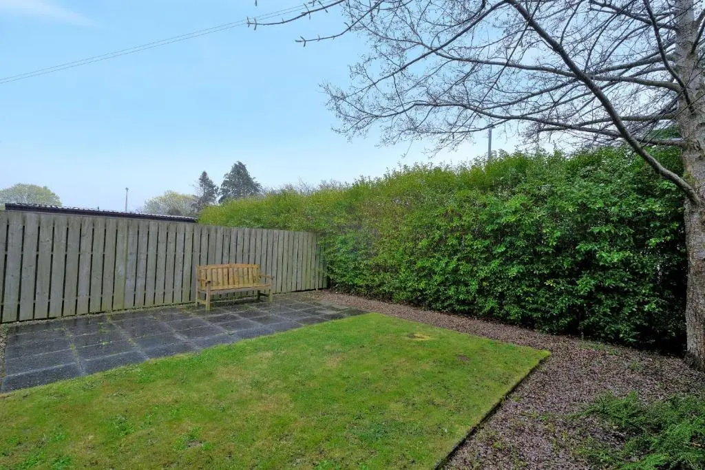 a bench sitting in a yard next to a fence at Caledonia Netherhills Apartment in Aberdeen