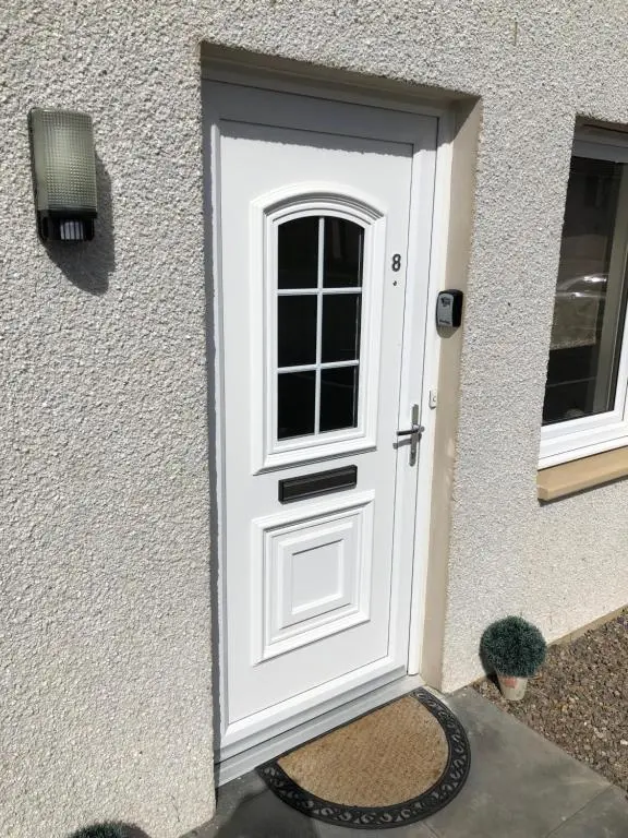 a white door with a window on a house at Foxglove Apartment in Inverness