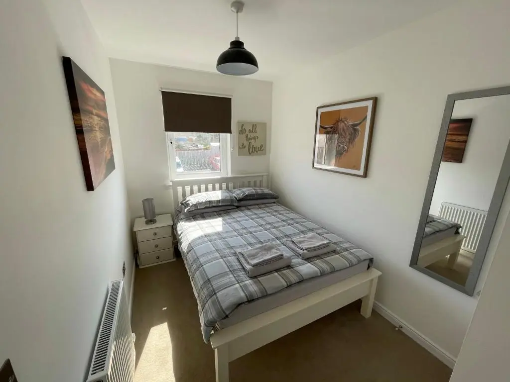 a bedroom with a bed and a mirror at Foxglove Apartment in Inverness