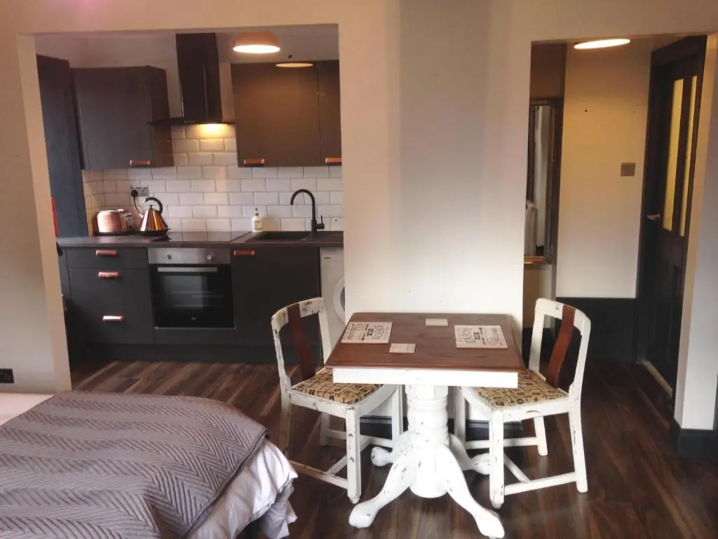 a kitchen with a table and chairs in a room at Caledonian Canal Studio in Inverness