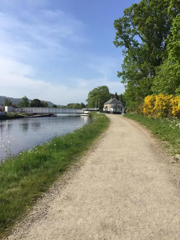 a dirt road next to a body of water at Caledonian Canal Studio in Inverness