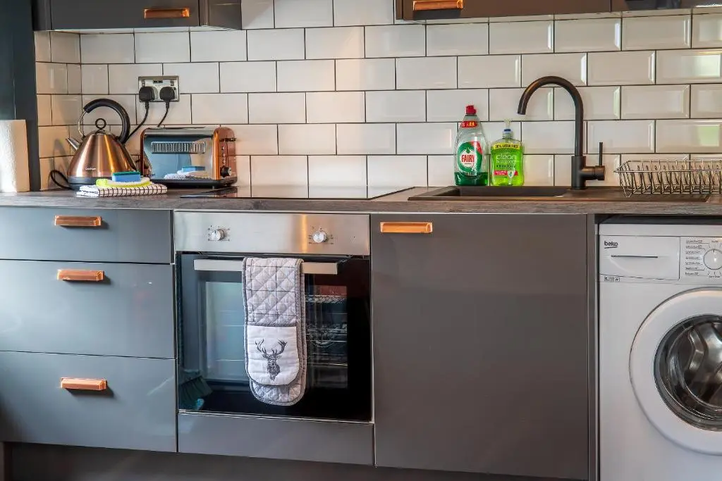 a kitchen with a dishwasher and a washing machine at Caledonian Canal Studio in Inverness