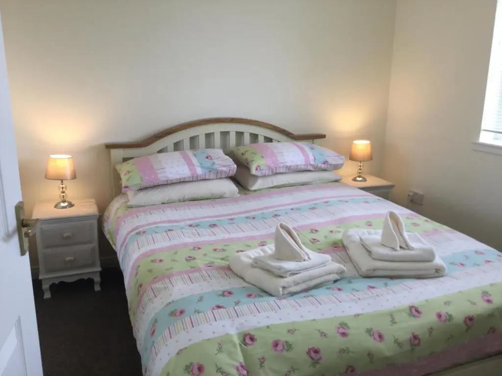 a bedroom with a bed with towels on it at Morning Field Apartment Free Parking in Inverness